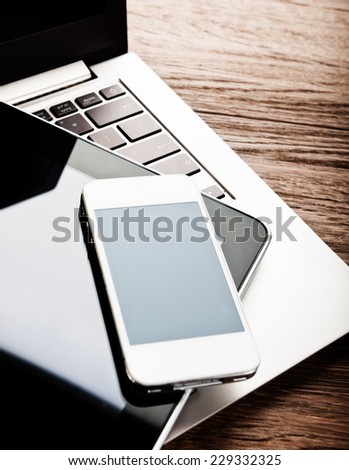 keyboard with phone and tablet pc on wooden desk