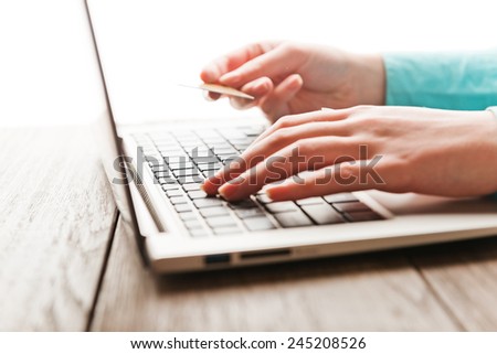 Female hands with credit card during shopping through Internet
