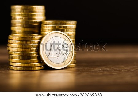 one euro coin and gold money on the desk
