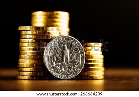 us quarter dollar coin and gold money on the desk