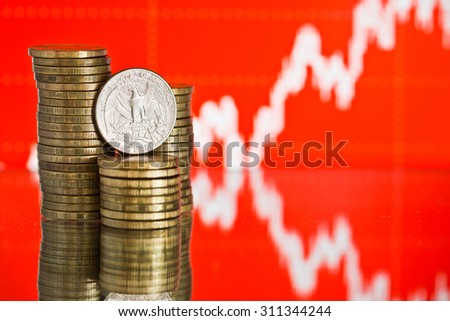 us quarter dollar coin and gold money. Fluctuating graph on red background. Rate of the american dollar (shallow DOF)