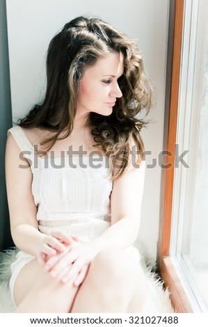 attractive young adult looking at the window with serious look