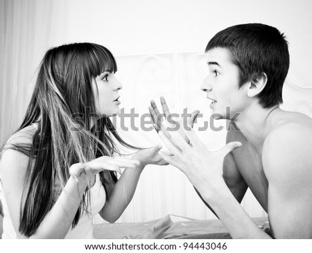 Portrait of an angry couple shouting each other against white background