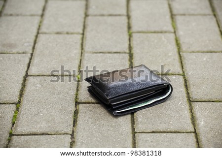 Lost black leather wallet with money lost at sidewalk