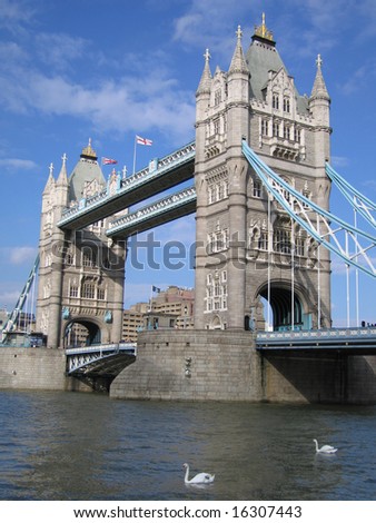 The two gothic towers of London Bridge with two swans on the River Thames