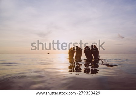 legs in the sea at sunset