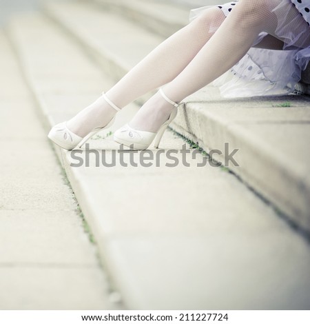 Legs of a bride sitting on step.