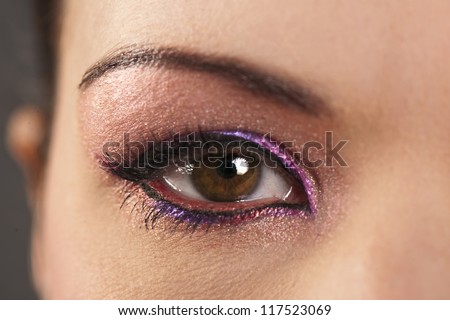 Close-up of beautiful woman\'s brown eye with graphic pink eyeliner