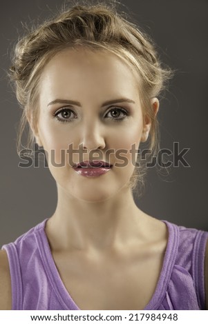 Beautiful blonde woman with natural makeup, plum lipstick and a romantic braided hairstyle