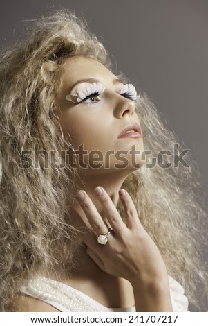 Portrait of blonde woman with pearl ring and fantasy makeup