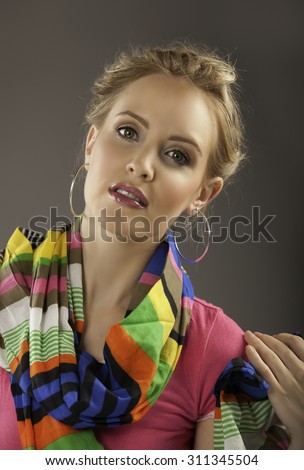 Portrait of gorgeous blonde lady with colorful striped scarf and silver hoop earrings