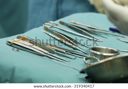 Sterile surgical instruments on theatre tray covered in sterile green drape