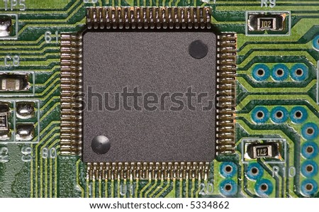 a microchip on green board with a lot of connections