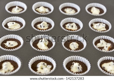 A muffin pan full of ready to bake Black Bottom Mini-Cupcakes. (Selective focus used in the image)