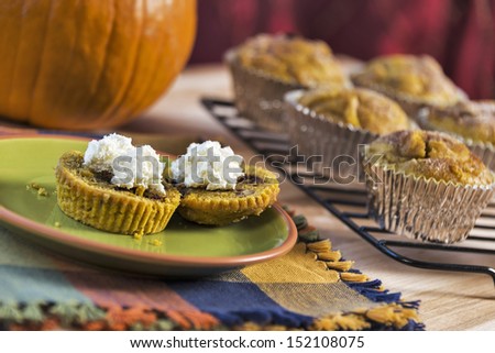 A traditional fall food, fresh baked pumpkin muffins are served with cream cheese.  One image in a series.