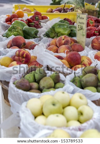 Colorful variety of fruits and vegetables for sale at a farmer\'s market produce stand.  Selective focus was used on this image.