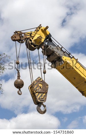 Crane hooks on a mobile crane waiting to hoist cargo on a construction site