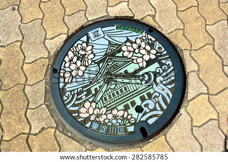 Osaka, Japan - July 19, 2010: Manhole cover in Osaka, Japan depicts Osaka Castle, one of the most famous landmarks of the city.