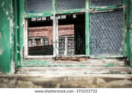 An old building is in ruins; you can see straight through to the other side through a broken window; horizontal format