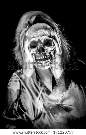 A female ghostly figure with a skull face; black and white colortone
