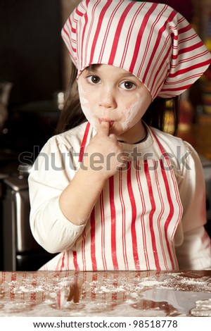 little chef in the kitchen wearing an apron and headscarf