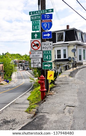 This road sign in the tiny village of Derby Line, VT marks the border between the US and Canada.  The Canadian customs inspection building is visible in the left side of the picture.