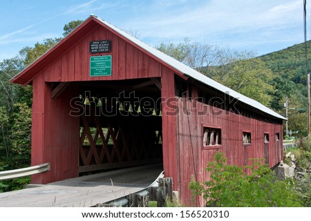 This old red wooden covered bridge crosses the Dog River in Northfield Falls, Vermont.