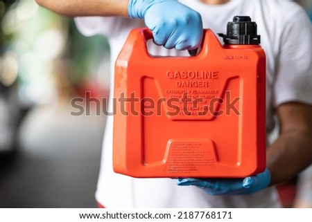man handle red plastic fuel gallon flammable material container for refill gasoline car tank Foto stock © 