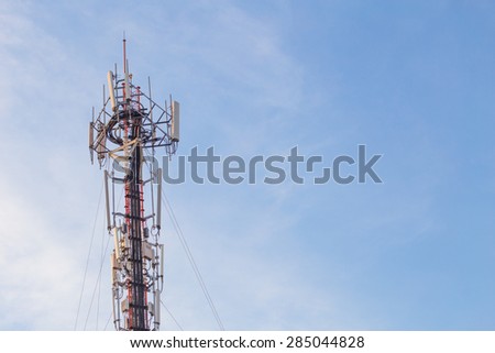Cell site, Telecommunications radio tower or mobile phone base station with atop the antennas with Blue Sky and cloud background.
