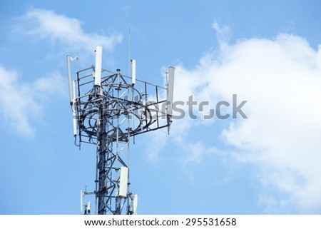 Cell site, Telecommunications radio tower or mobile phone base station with cloud and blue sky background