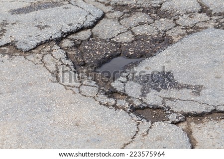 Bad old road, big hole in street asphalt