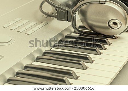 Digital midi keyboard and headphones in the studio.