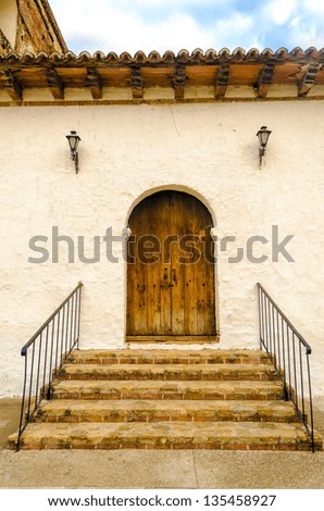 A wooden colonial door on the side of an old church