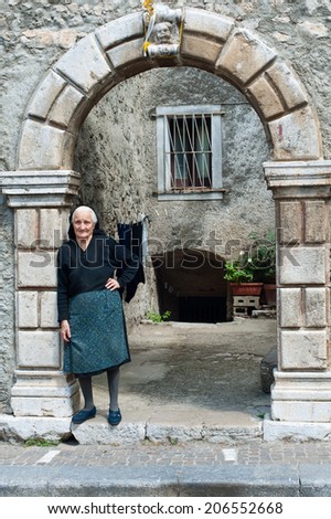 Cilento, Italy - July 29, 2011: Old italian woman stays in Cilento arch of her house. Photo taken on 29th of July, 2011 in Cilento and Vallo di Diano National Park.