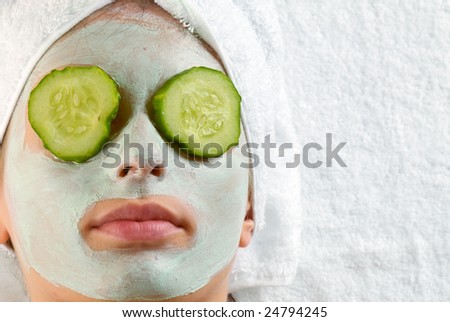 Woman with cucumbers and face mask