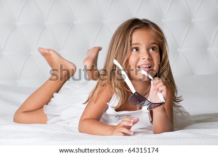 Portrait of cute girl with goggles lying barefoot in the bed