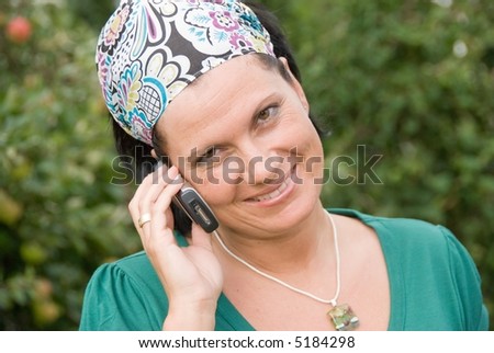 A pretty woman is smiling while talking on a cellphone, handy