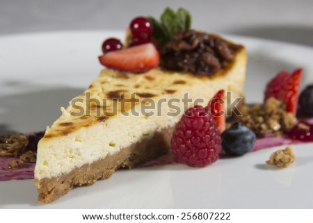 Cheese cake with strawberry sauce, black currant caviar, seasonal berries and caramelized walnuts