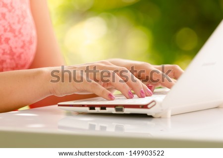 Lady hands and laptop against green background