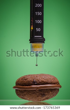 Insulin pen and cookie against green background