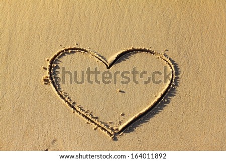 Heart drawn in the sand on the beach