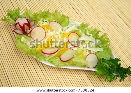 Decorative and colorful salad with lettuce, radish and peppers.