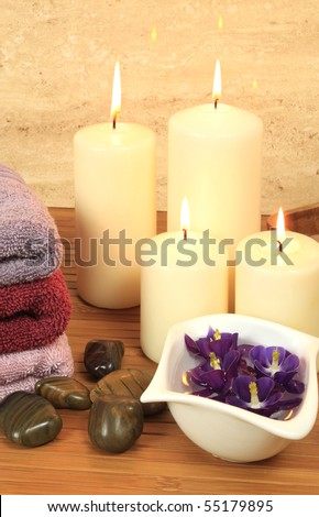 Spa resort composition - candles, towels, orchid flowers, zen stones