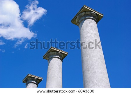 Three pillars reach the sky at a ruins of a mansion.
