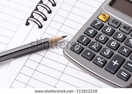 Gray pencil and calculator lying on opened account book