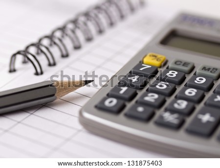 Gray pencil, calculator and opened account book
