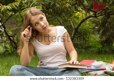 Portrait of a college student with book and bag, thinking about exam