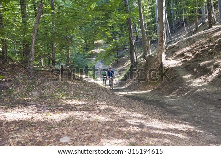 Bike Forest bike /Bikers riding through the forest during the cross country MTB competition within Oltenia\'s Marathon event. Ramnicu Valcea, Romania, August 29, 2015