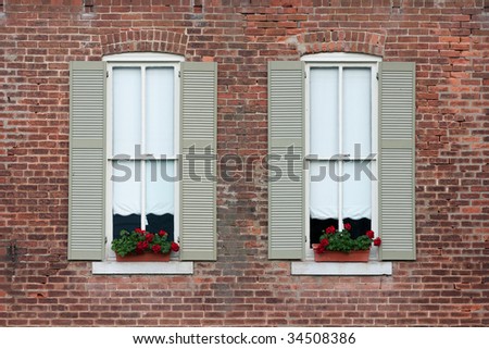flower boxes in windows with shutters on old brick home