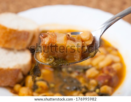 Potaje de Garbanzos y espinacas. Spanish cuisine. Stewed chickpeas with spinach. Image shows a full spoon